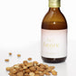 Bottle of faenix oil with almonds on a white background