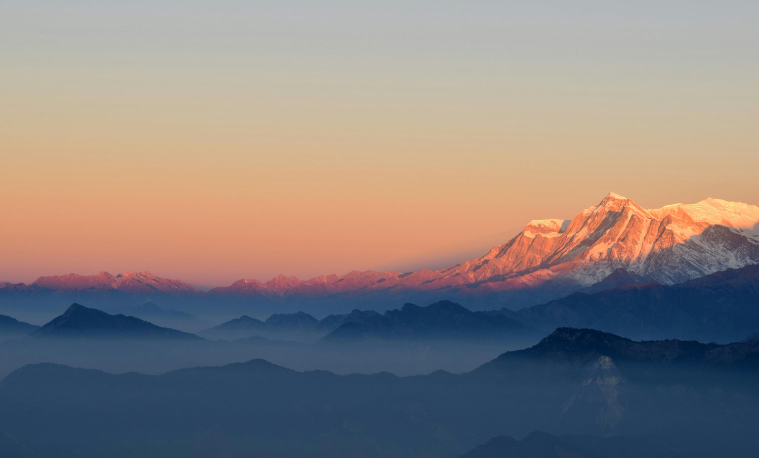 Sunrise over mountain range with snow-capped peaks